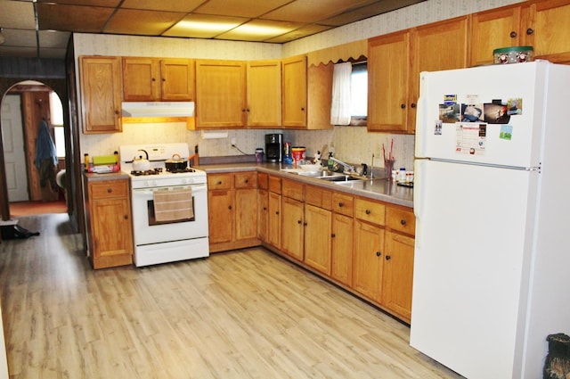 kitchen with white appliances, sink, light wood-type flooring, and a drop ceiling