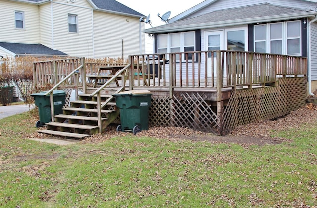 rear view of property featuring a wooden deck and a yard