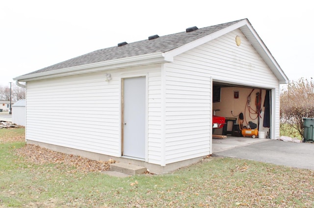 view of outbuilding featuring a garage and a lawn