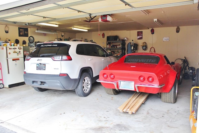 garage featuring a garage door opener and white refrigerator