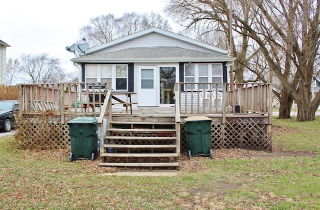 back of property with a yard and a deck