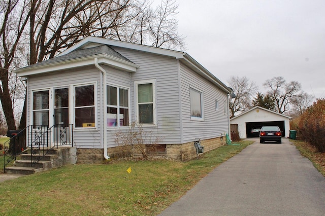 view of front of home featuring an outbuilding, a garage, and a front lawn