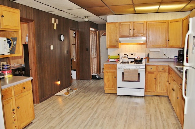 kitchen featuring wood walls, tasteful backsplash, white appliances, light hardwood / wood-style floors, and a drop ceiling