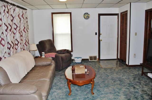 living room with dark carpet and a paneled ceiling