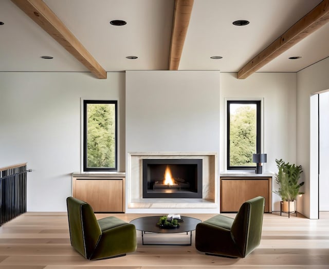 interior space with beamed ceiling, light wood-type flooring, and a fireplace