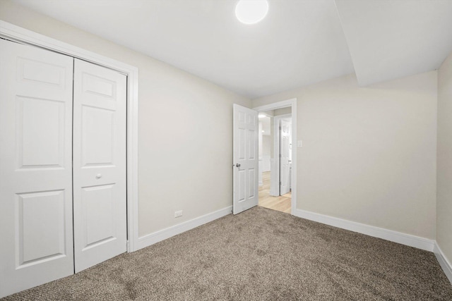 unfurnished bedroom featuring light colored carpet and a closet