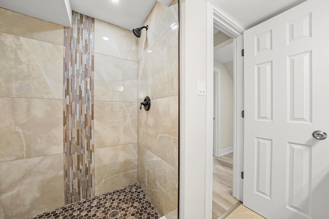 bathroom featuring wood-type flooring and tiled shower