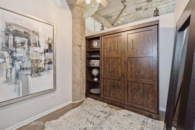 room details with baseboards, wood finished floors, a ceiling fan, and track lighting