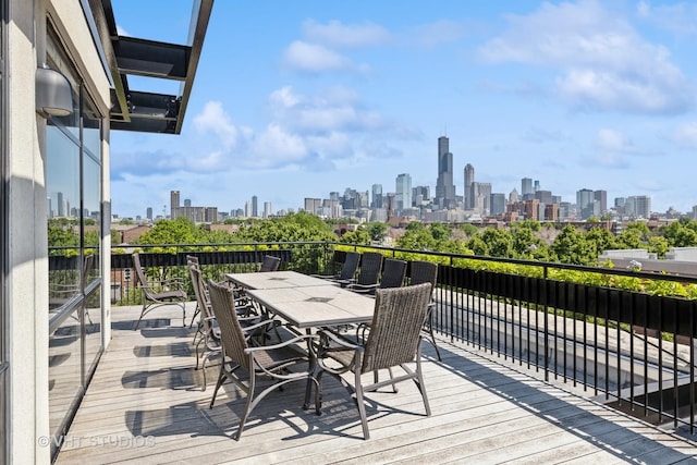 wooden terrace featuring a view of city and outdoor dining area