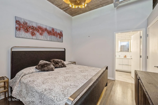 bedroom with ceiling fan, light hardwood / wood-style floors, and ensuite bath