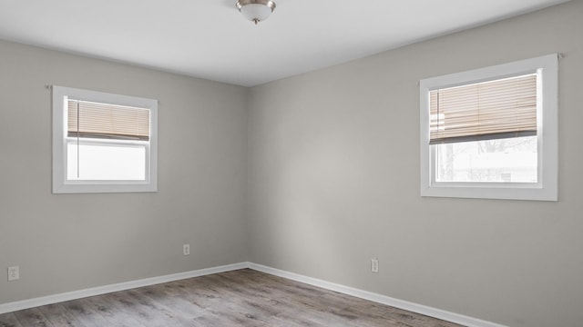 empty room with light hardwood / wood-style flooring and a wealth of natural light