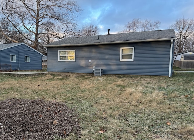 rear view of house with a lawn and central air condition unit