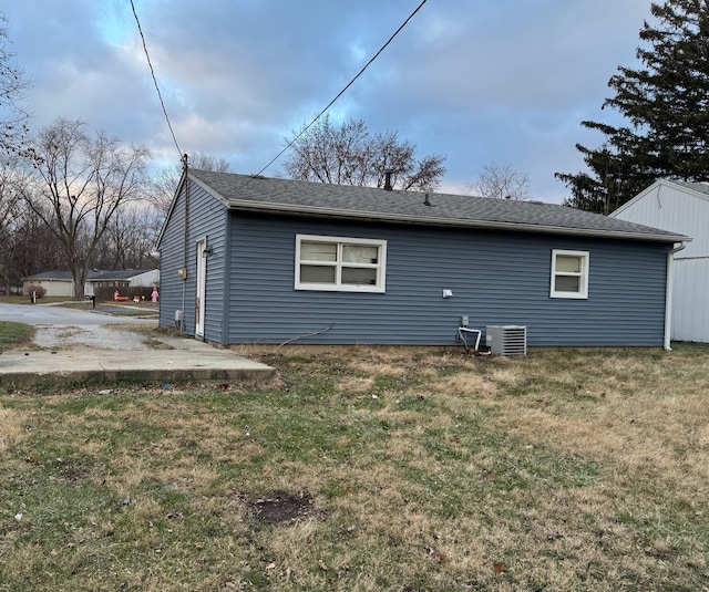 back of property with a patio area, a yard, and central AC