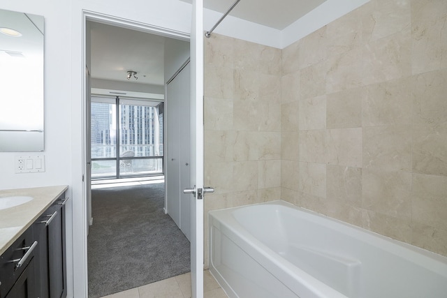 bathroom with tile patterned floors, vanity, and tiled shower / bath