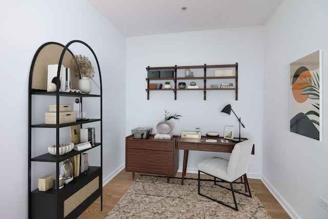 home office with light hardwood / wood-style flooring