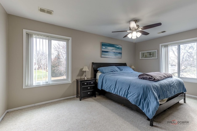 bedroom with multiple windows, ceiling fan, and carpet floors