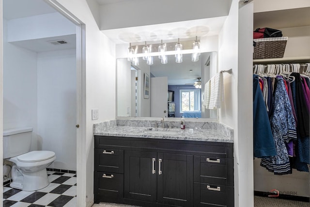 bathroom featuring vanity, toilet, and ceiling fan