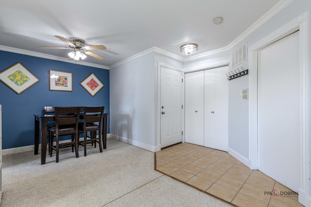 tiled dining room with ceiling fan and crown molding