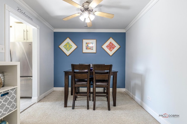 carpeted dining area featuring ceiling fan and ornamental molding