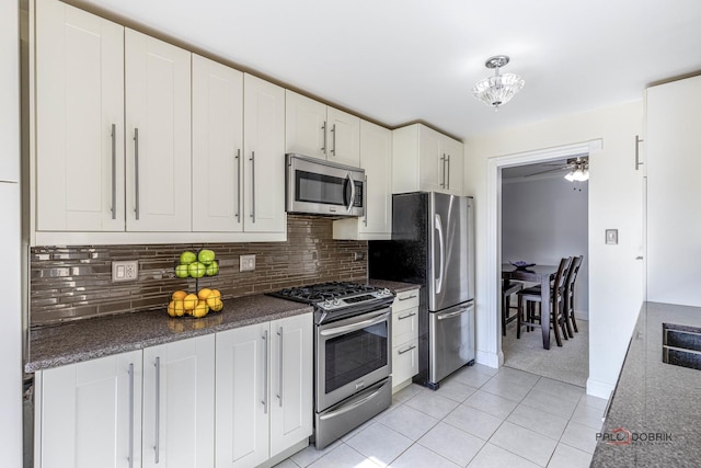 kitchen featuring white cabinets, light tile patterned floors, stainless steel appliances, and tasteful backsplash