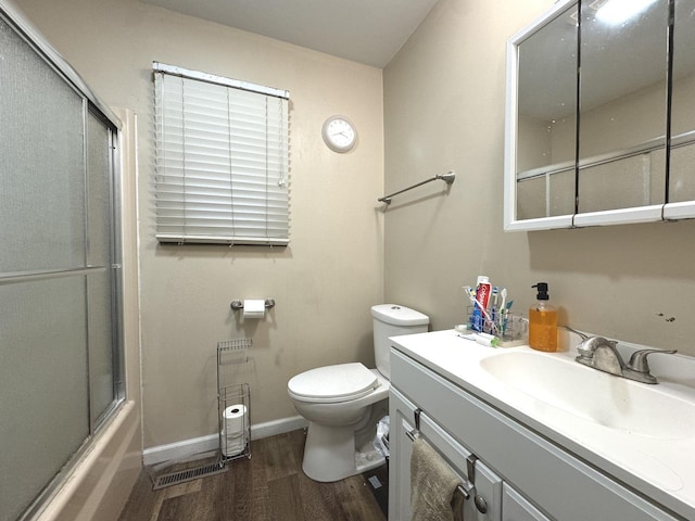 full bathroom featuring vanity, toilet, wood-type flooring, and combined bath / shower with glass door