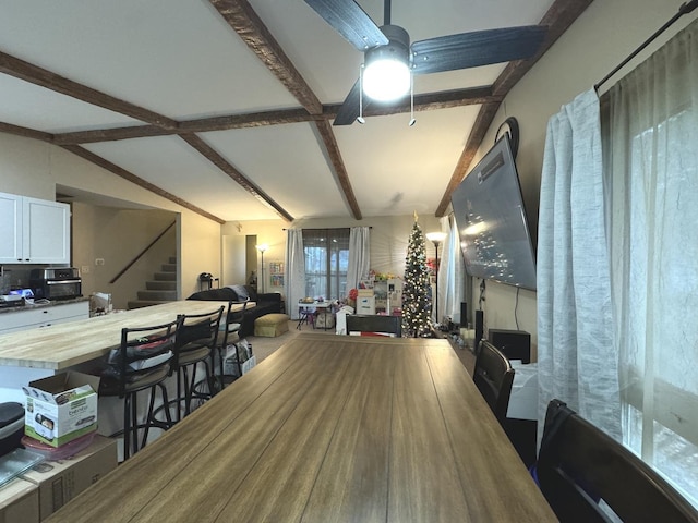 dining area featuring vaulted ceiling with beams and ceiling fan