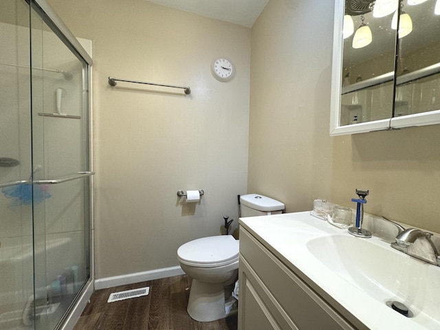 bathroom featuring hardwood / wood-style flooring, vanity, toilet, and a shower with shower door