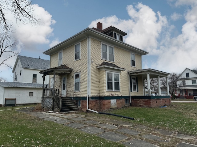 rear view of property featuring a yard