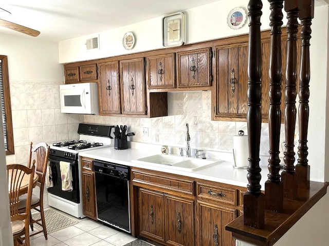 kitchen with tasteful backsplash, sink, light tile patterned flooring, and white appliances