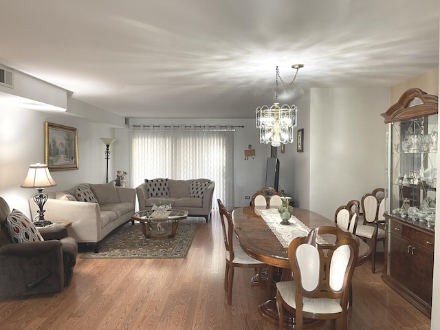 dining area with an inviting chandelier and hardwood / wood-style flooring