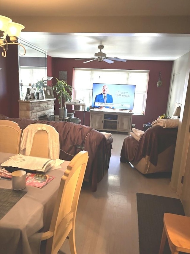 dining room featuring ceiling fan, wood-type flooring, and a fireplace