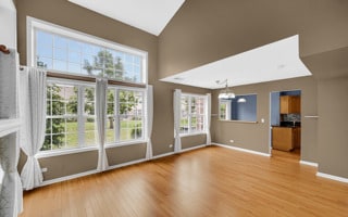 unfurnished living room featuring hardwood / wood-style floors and lofted ceiling