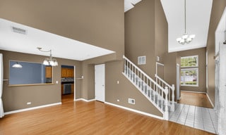 unfurnished living room featuring hardwood / wood-style floors and a chandelier