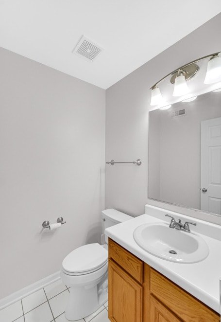 bathroom featuring tile patterned floors, vanity, and toilet