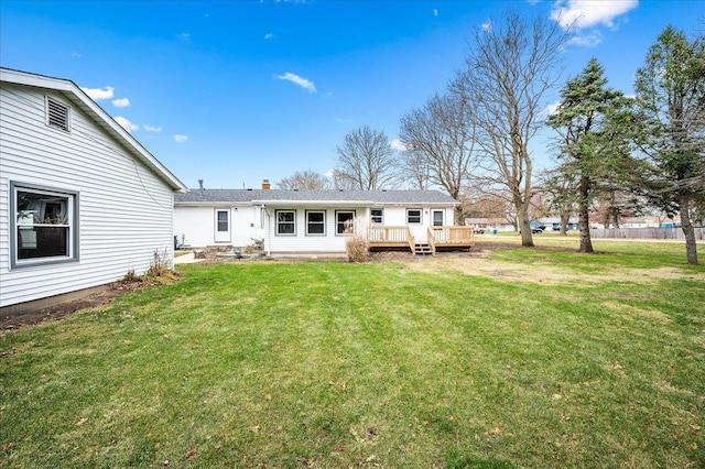 back of house featuring a deck and a yard