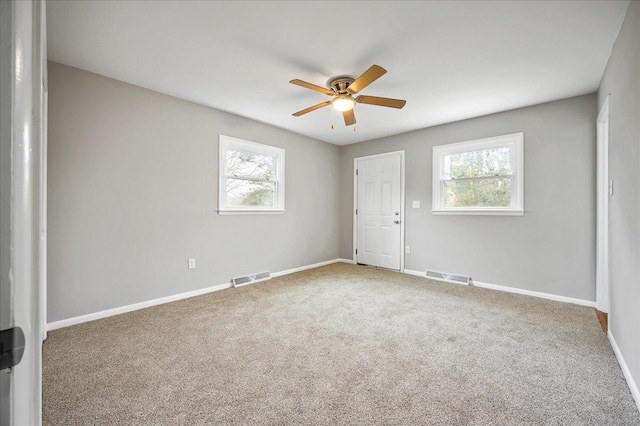 empty room with carpet, plenty of natural light, and ceiling fan