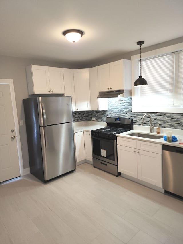 kitchen featuring white cabinets, pendant lighting, stainless steel appliances, and decorative backsplash