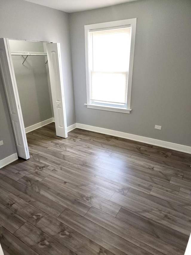 unfurnished bedroom featuring dark hardwood / wood-style floors and a closet