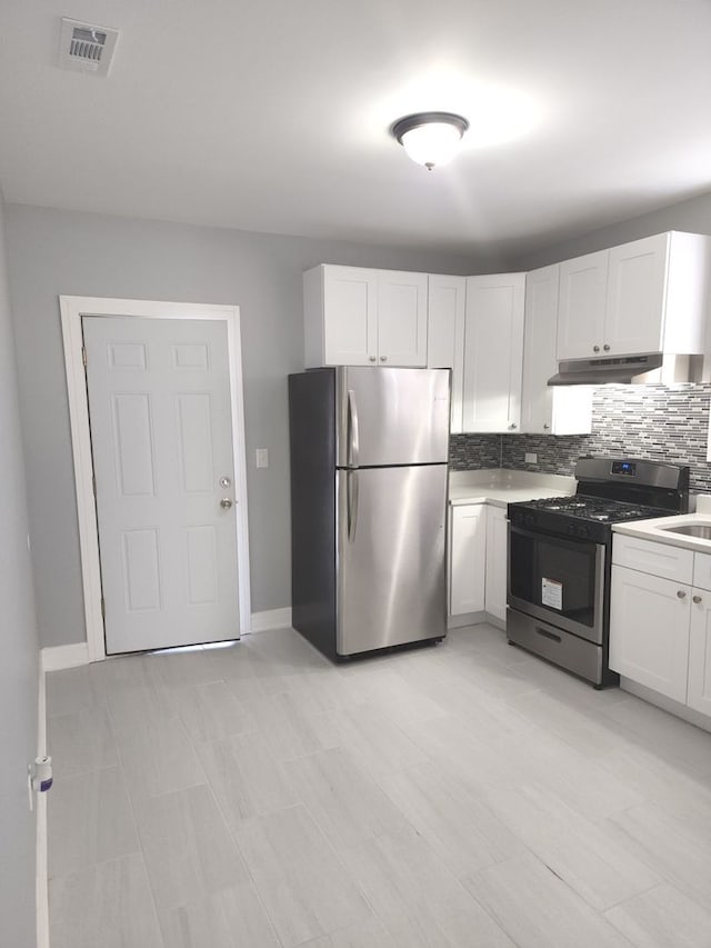 kitchen with backsplash, sink, white cabinets, and stainless steel appliances