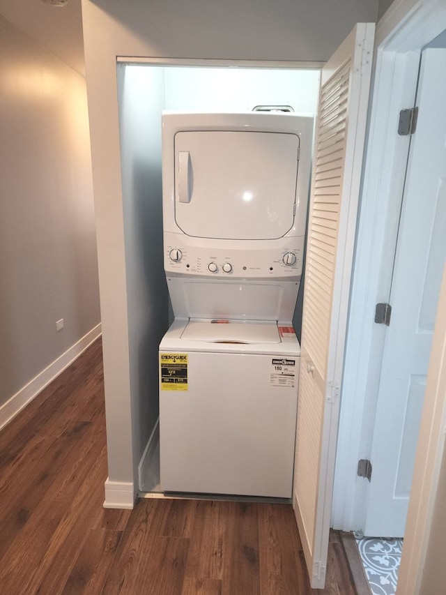 clothes washing area with stacked washer / dryer and dark hardwood / wood-style flooring