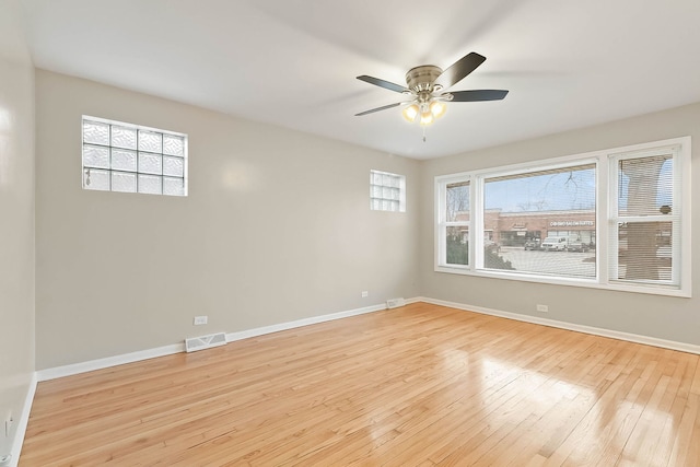 empty room with light hardwood / wood-style floors, ceiling fan, and a healthy amount of sunlight