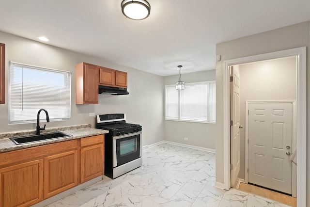 kitchen with pendant lighting, stainless steel gas stove, and sink