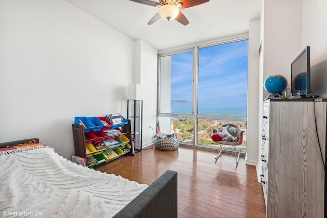 bedroom featuring floor to ceiling windows, ceiling fan, and hardwood / wood-style flooring