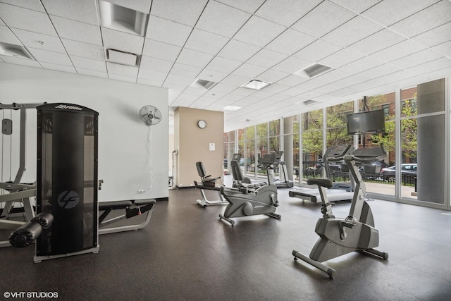 workout area with a drop ceiling, floor to ceiling windows, and a wealth of natural light