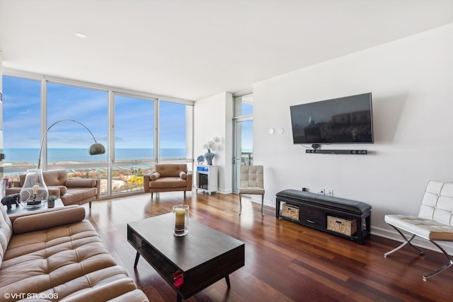 living room featuring a water view, floor to ceiling windows, and dark wood-type flooring