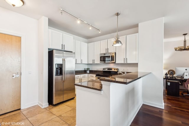 kitchen featuring kitchen peninsula, stainless steel appliances, decorative light fixtures, light hardwood / wood-style floors, and white cabinetry