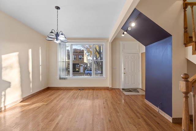 entryway with wood-type flooring and a notable chandelier