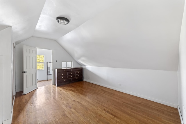 additional living space featuring hardwood / wood-style floors and vaulted ceiling