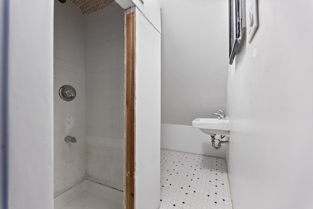 bathroom with a tile shower and sink