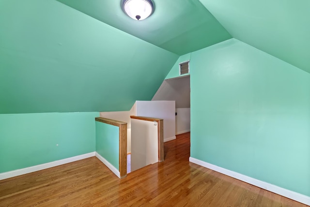 bonus room with vaulted ceiling and light hardwood / wood-style flooring